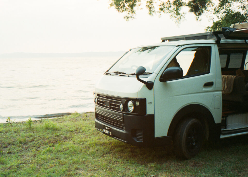 海沿いに停車する丸目のハイエース V-01