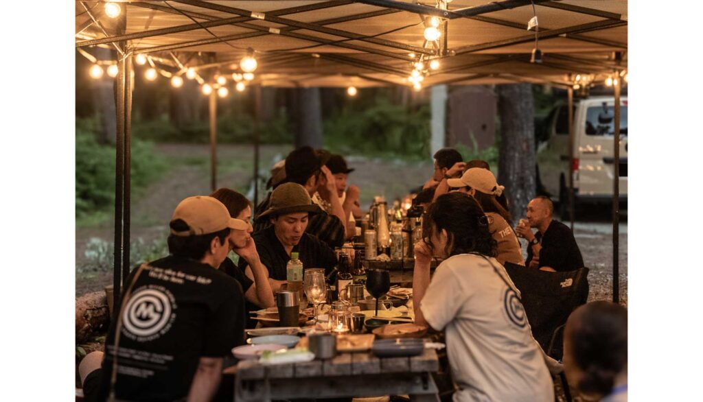 参加者同士で食事とお酒を楽しむキャンプの夜