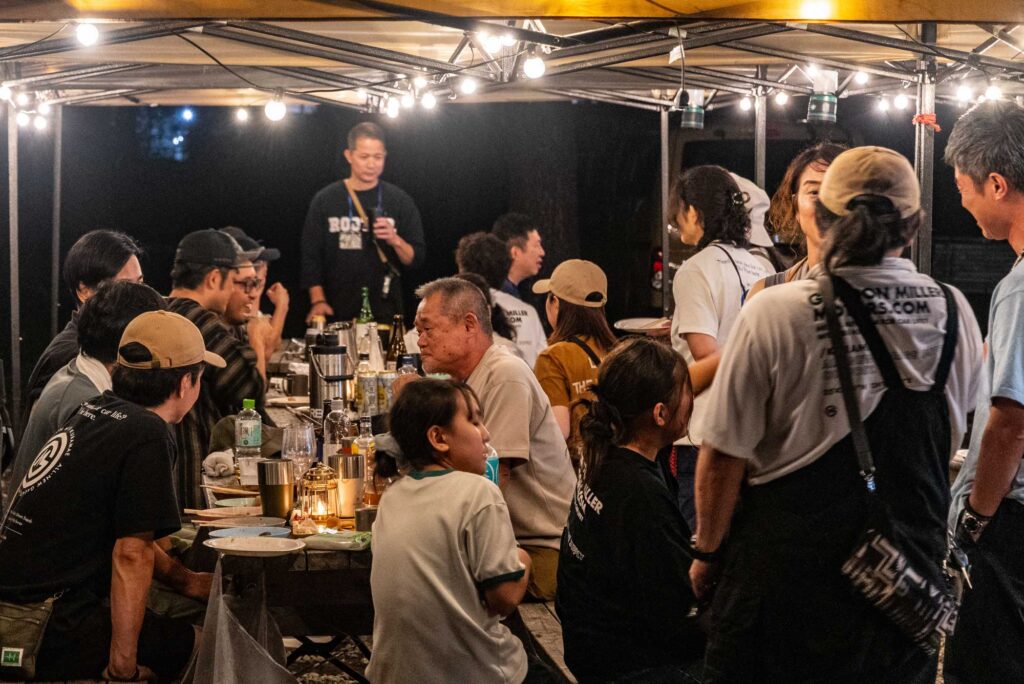 参加者同士で食事とお酒を楽しむキャンプの夜