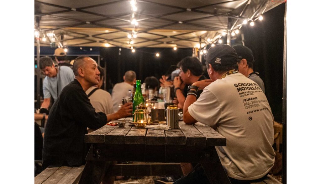 参加者同士で食事とお酒を楽しむキャンプの夜