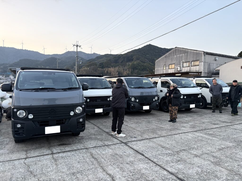 ハイエースとキャラバンが並ぶ前で挨拶するオーナーさん